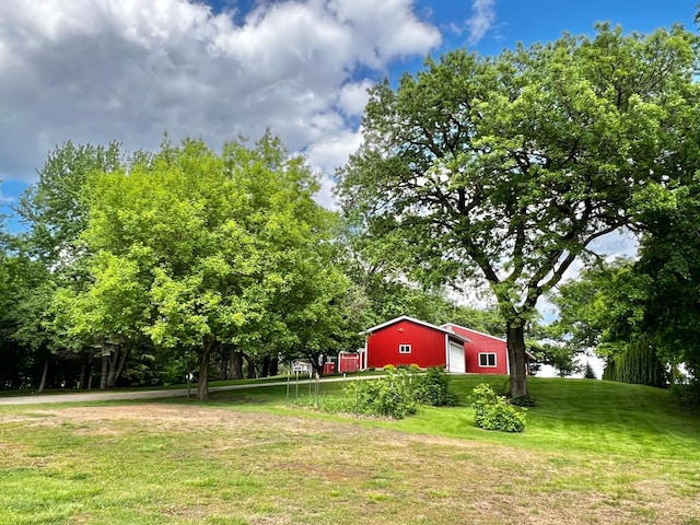 17300 Baseline Ave, Sand Creek Twp, MN 55352 - view of grassy yard with an outbuilding, an outdoor structure, and view of scattered trees