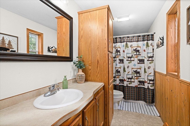 2614 Leroy Rd, Eveleth, MN 55734 - full bathroom with toilet, vanity, a shower with curtain, wainscoting, and wood walls