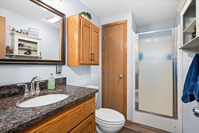 2614 Leroy Rd, Eveleth, MN 55734 - full bathroom with a shower stall, wood finished floors, vanity, and toilet