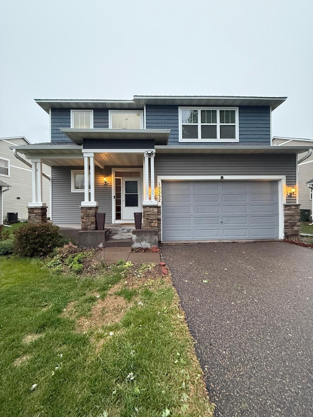 12332 3rd St NE, Blaine, MN 55434 - view of front of home featuring asphalt driveway, a porch, a garage, stone siding, and central AC