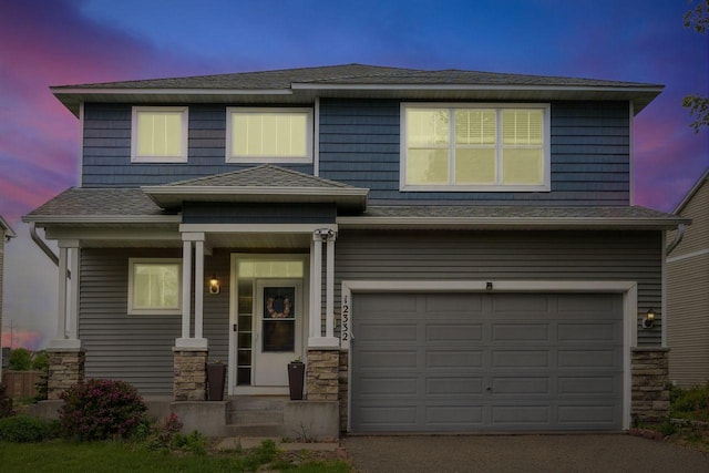 12332 3rd St NE, Blaine, MN 55434 - view of front of house featuring a garage, roof with shingles, stone siding, and asphalt driveway