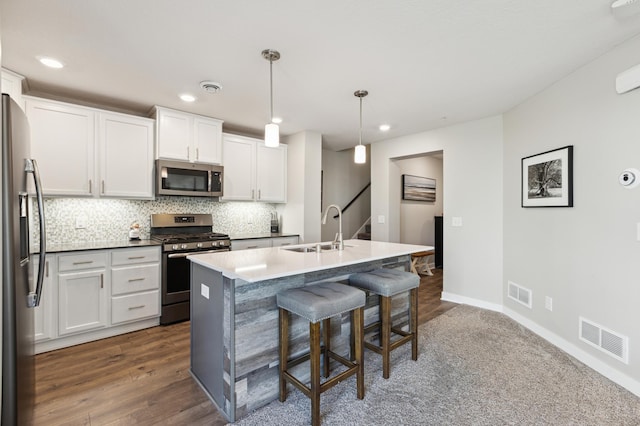 11564 Woodside Dr, Rogers, MN 55311 - kitchen with stainless steel appliances, a sink, tasteful backsplash, white cabinetry, and a breakfast bar area