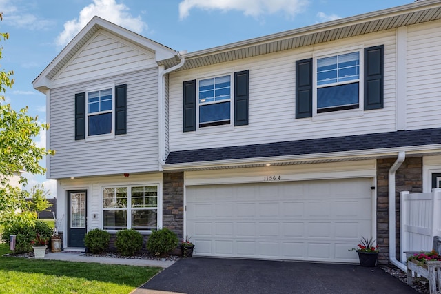 11564 Woodside Dr, Rogers, MN 55311 - view of property featuring stone siding, driveway, and an attached garage