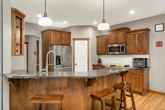 2349 175th Ln NE, Ham Lake, MN 55304 - kitchen with stainless steel appliances, arched walkways, recessed lighting, dark stone countertops, and a peninsula