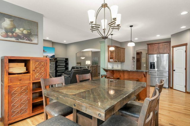 2349 175th Ln NE, Ham Lake, MN 55304 - dining area featuring arched walkways, light wood-style flooring, a chandelier, and recessed lighting