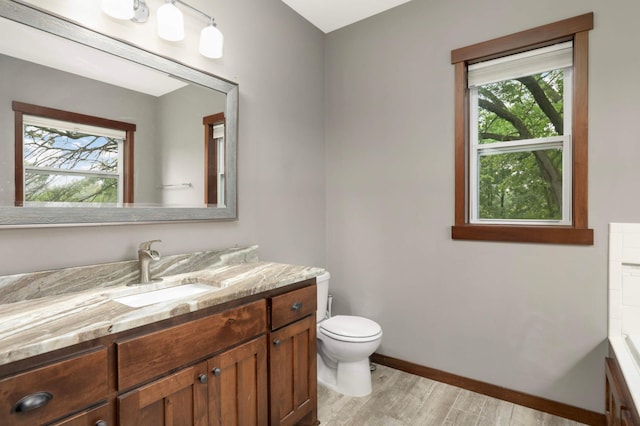 2349 175th Ln NE, Ham Lake, MN 55304 - bathroom featuring wood finished floors, toilet, vanity, and plenty of natural light