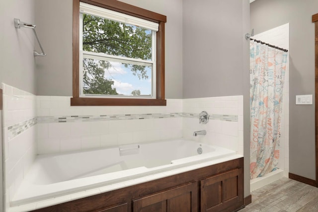 2349 175th Ln NE, Ham Lake, MN 55304 - full bath featuring a bath, a shower stall, wood finished floors, and baseboards