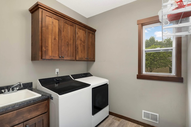 2349 175th Ln NE, Ham Lake, MN 55304 - laundry room with independent washer and dryer, cabinet space, light wood-type flooring, and baseboards