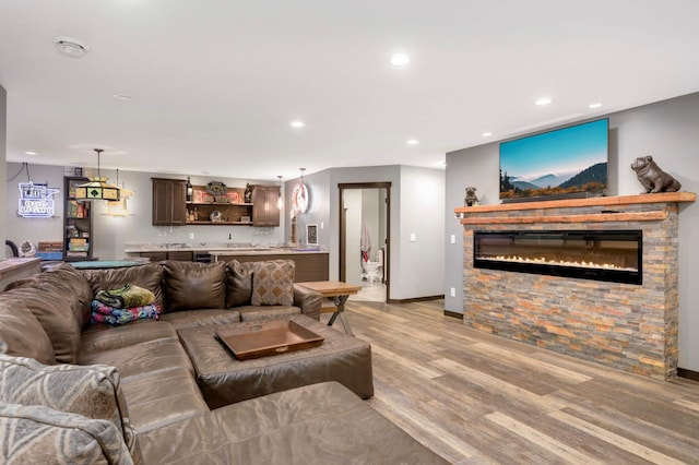 2349 175th Ln NE, Ham Lake, MN 55304 - living area with light wood-type flooring, a glass covered fireplace, recessed lighting, bar with sink, and baseboards