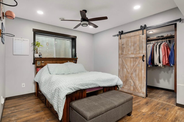 2349 175th Ln NE, Ham Lake, MN 55304 - bedroom with a barn door, baseboards, wood finished floors, a closet, and a spacious closet