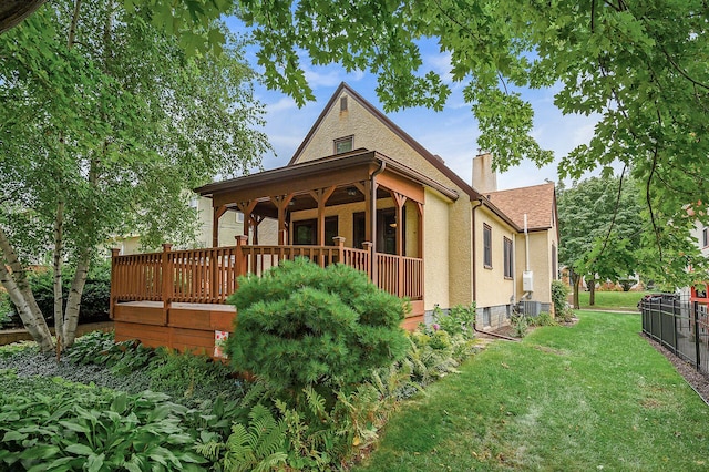 1928 Cleveland St NE, Minneapolis, MN 55418 - back of house with a chimney, a lawn, central AC, and stucco siding