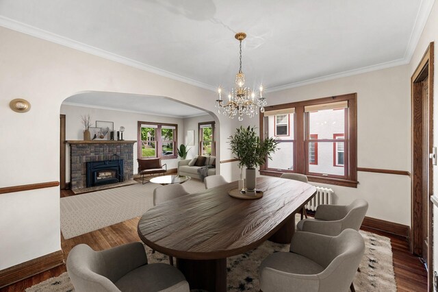 1928 Cleveland St NE, Minneapolis, MN 55418 - dining space with arched walkways, baseboards, radiator, wood finished floors, and crown molding
