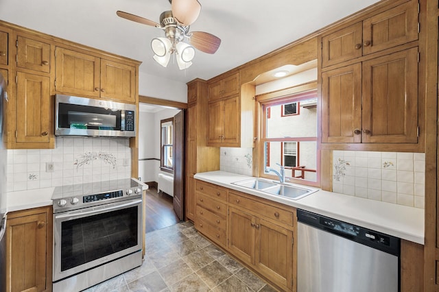 1928 Cleveland St NE, Minneapolis, MN 55418 - kitchen featuring appliances with stainless steel finishes, a sink, a ceiling fan, light countertops, and backsplash