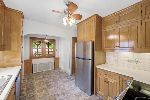 1928 Cleveland St NE, Minneapolis, MN 55418 - kitchen featuring appliances with stainless steel finishes, radiator heating unit, arched walkways, and light countertops