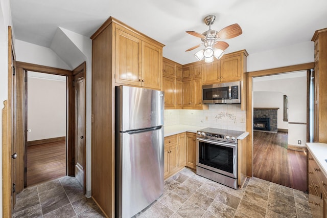 1928 Cleveland St NE, Minneapolis, MN 55418 - kitchen featuring stainless steel appliances, ceiling fan, light countertops, a fireplace, and tasteful backsplash