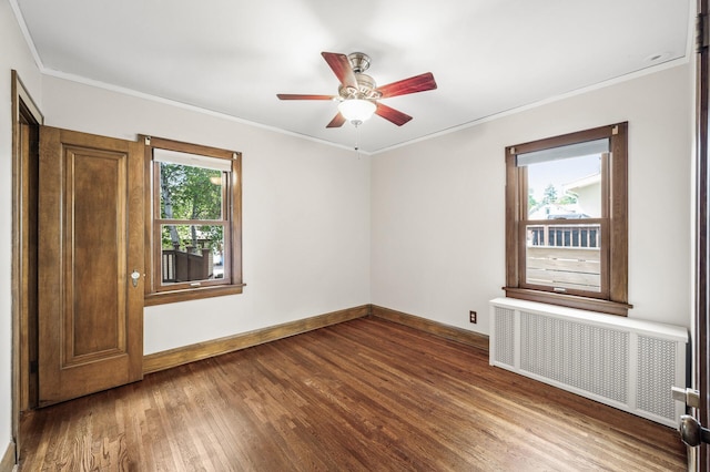 1928 Cleveland St NE, Minneapolis, MN 55418 - spare room featuring radiator, dark wood finished floors, baseboards, a ceiling fan, and crown molding