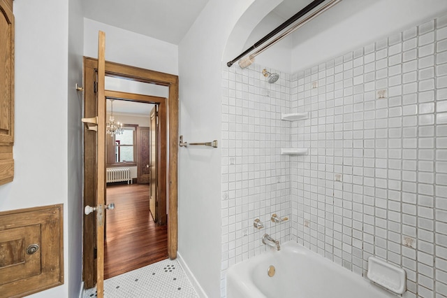 1928 Cleveland St NE, Minneapolis, MN 55418 - bathroom with radiator, tub / shower combination, a chandelier, baseboards, and tile patterned flooring