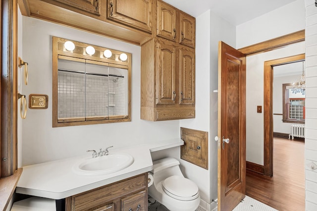 1928 Cleveland St NE, Minneapolis, MN 55418 - bathroom featuring radiator, toilet, vanity, and wood finished floors