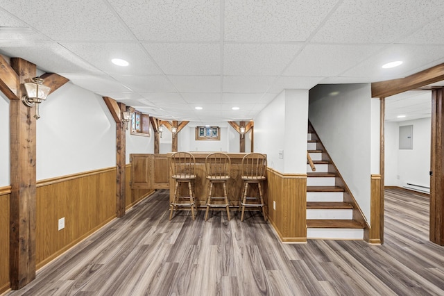 1928 Cleveland St NE, Minneapolis, MN 55418 - indoor dry bar featuring a drop ceiling, wood finished floors, a wainscoted wall, wooden walls, and stairs