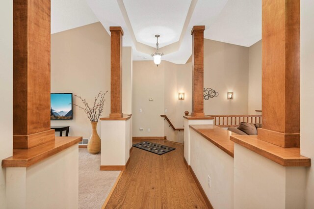 14550 Hunters Ln, Savage, MN 55378 - hall featuring decorative columns, light wood-type flooring, a tray ceiling, and baseboards