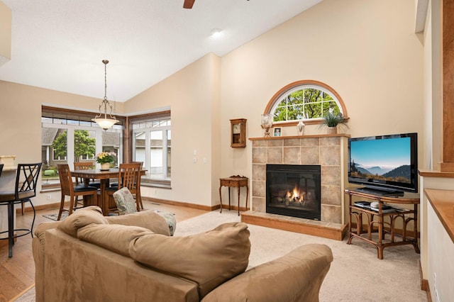 14550 Hunters Ln, Savage, MN 55378 - living area featuring a tile fireplace, healthy amount of natural light, a ceiling fan, high vaulted ceiling, and baseboards