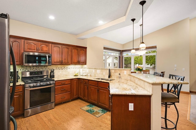 14550 Hunters Ln, Savage, MN 55378 - kitchen featuring stainless steel appliances, a breakfast bar area, a sink, a peninsula, and backsplash