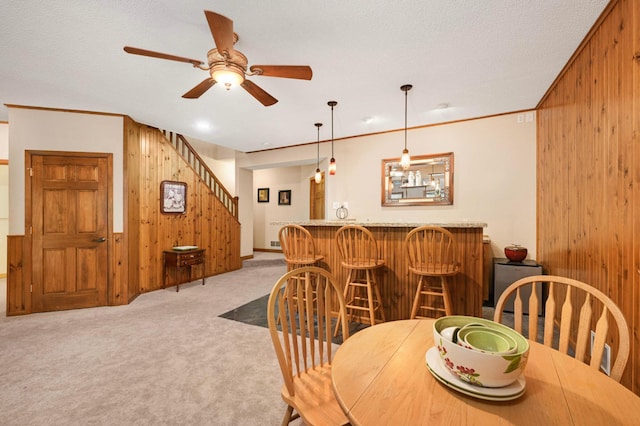14550 Hunters Ln, Savage, MN 55378 - dining area with wooden walls, wet bar, carpet floors, a ceiling fan, and stairs