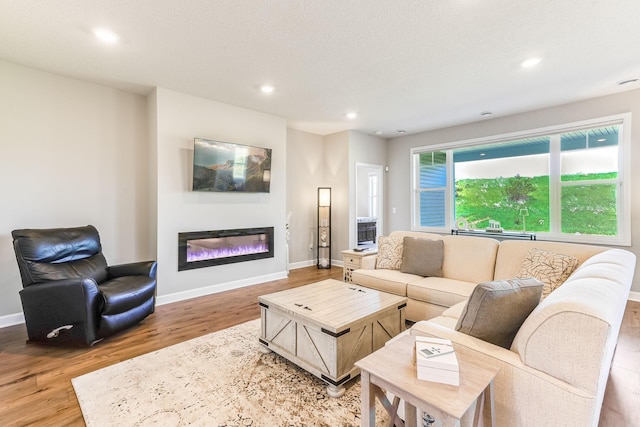 19171 Cottage Rd, Farmington, MN 55024 - living room featuring wood finished floors, a glass covered fireplace, recessed lighting, and baseboards