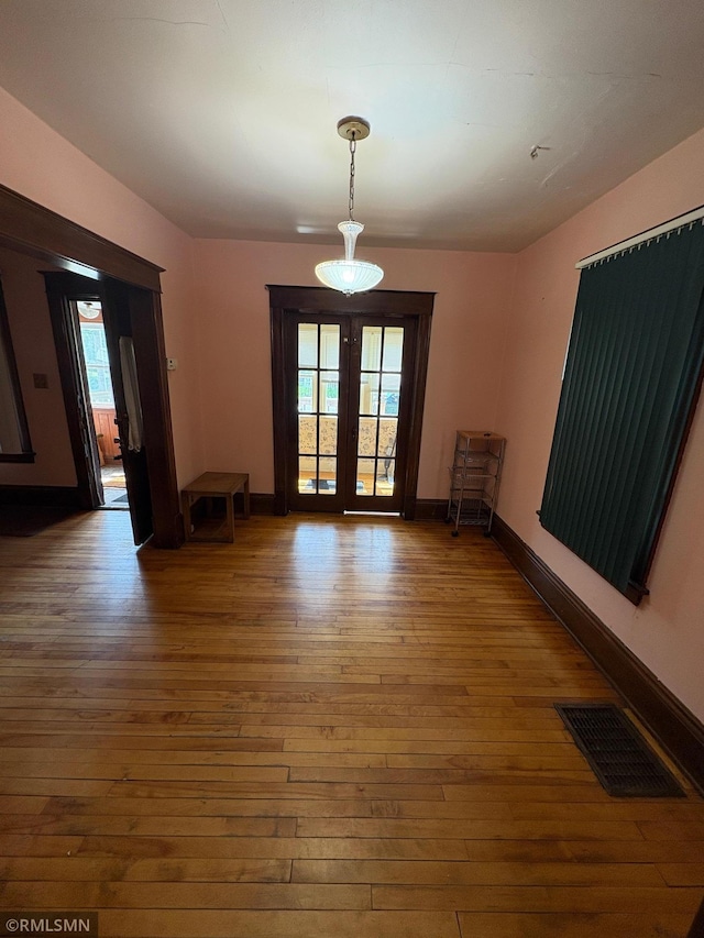 3934 Hubbard Ave N, Robbinsdale, MN 55422 - empty room featuring hardwood / wood-style flooring, plenty of natural light, french doors, and baseboards