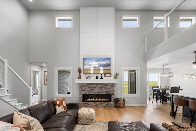 4533 38 1/2 Ave N, Reiles Acres, ND 58102 - living area featuring a high ceiling, hardwood / wood-style flooring, plenty of natural light, a stone fireplace, and stairway