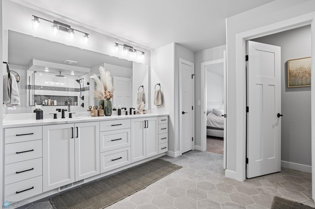 4533 38 1/2 Ave N, Reiles Acres, ND 58102 - ensuite bathroom featuring double vanity, a shower stall, baseboards, and tile patterned flooring
