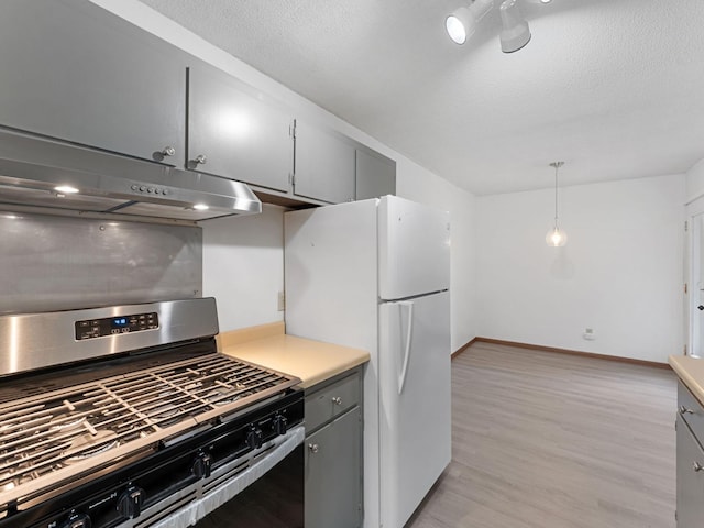 26 Arthur Ave SE Unit 304, Minneapolis, MN 55414 - kitchen featuring stainless steel range with gas stovetop, under cabinet range hood, freestanding refrigerator, gray cabinetry, and light wood finished floors