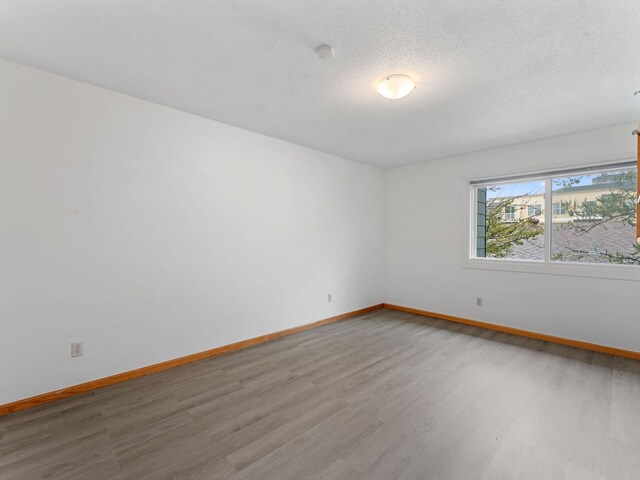26 Arthur Ave SE Unit 304, Minneapolis, MN 55414 - spare room with wood finished floors, baseboards, and a textured ceiling