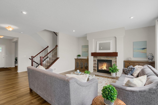 1721 Pebblestone Rd, Carver, MN 55315 - living area featuring wood finished floors, stairs, baseboards, a stone fireplace, and recessed lighting