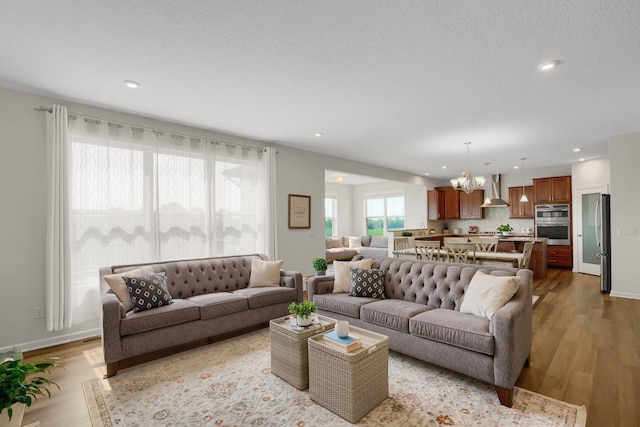 1721 Pebblestone Rd, Carver, MN 55315 - living area featuring a chandelier, wood finished floors, recessed lighting, and baseboards