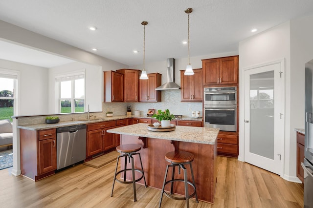 1721 Pebblestone Rd, Carver, MN 55315 - kitchen featuring appliances with stainless steel finishes, wall chimney exhaust hood, a sink, light wood-type flooring, and recessed lighting