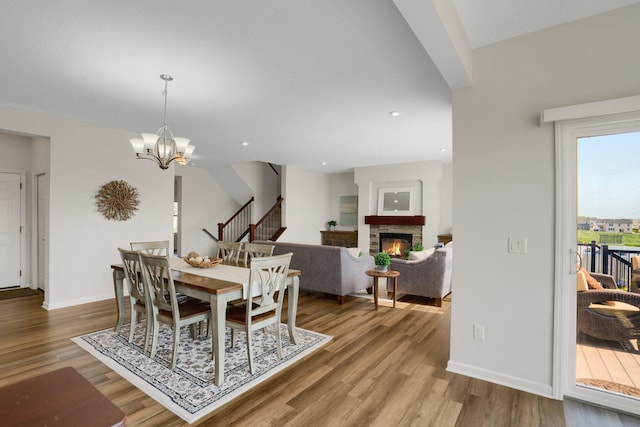 1721 Pebblestone Rd, Carver, MN 55315 - dining space with wood finished floors, a stone fireplace, a chandelier, baseboards, and recessed lighting
