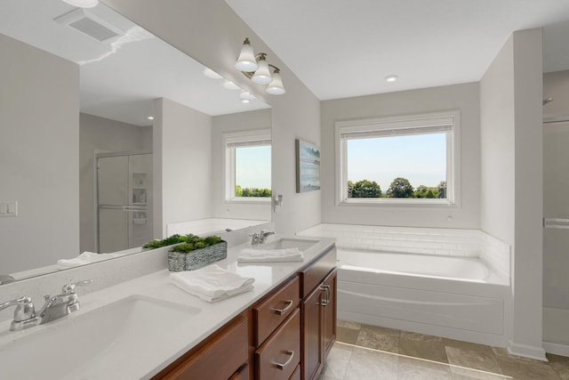 1721 Pebblestone Rd, Carver, MN 55315 - bathroom with a shower stall, a garden tub, double vanity, recessed lighting, and stone finish floors