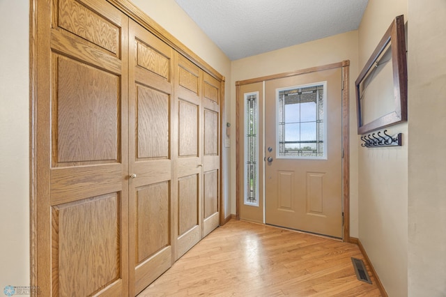 20482 28th Ave N, Cromwell Twp, MN 56549 - doorway featuring light wood finished floors, baseboards, and a textured ceiling