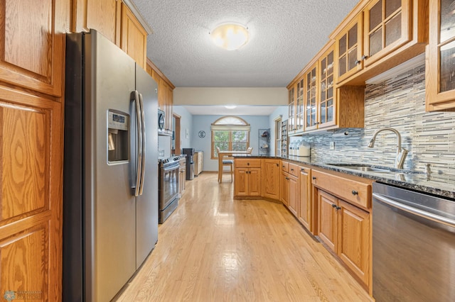 20482 28th Ave N, Cromwell Twp, MN 56549 - kitchen featuring stainless steel appliances, a sink, light wood-type flooring, a peninsula, and backsplash