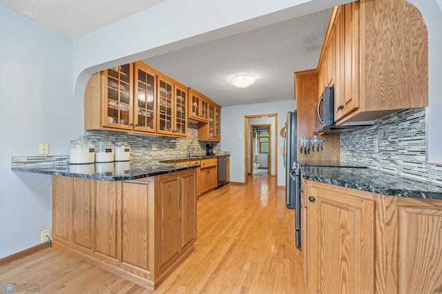 20482 28th Ave N, Cromwell Twp, MN 56549 - kitchen with dishwashing machine, light wood-style flooring, baseboards, a peninsula, and backsplash