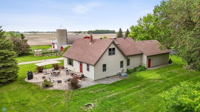20482 28th Ave N, Cromwell Twp, MN 56549 - rear view of property featuring a patio area, a lawn, central AC, and a chimney