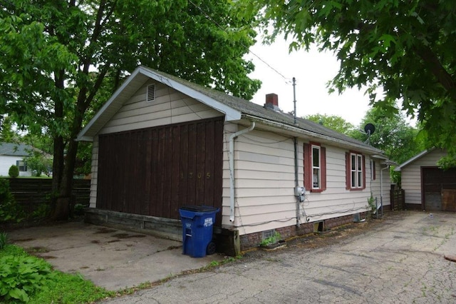 1305 La Crescent St, Campbell Twp, WI 54603 - view of property exterior featuring a chimney, a detached garage, and an outbuilding