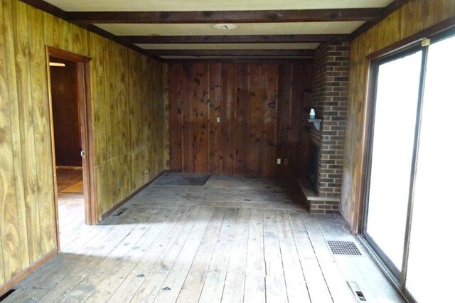 1305 La Crescent St, Campbell Twp, WI 54603 - empty room with wooden walls, beam ceiling, and hardwood / wood-style floors