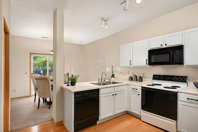 547 Woodduck Dr Unit G, Woodbury, MN 55125 - kitchen with black appliances, a sink, light wood-type flooring, light countertops, and white cabinetry