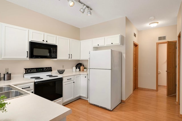 547 Woodduck Dr Unit G, Woodbury, MN 55125 - kitchen featuring black microwave, freestanding refrigerator, range with electric stovetop, light wood finished floors, and light countertops