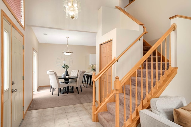 547 Woodduck Dr Unit G, Woodbury, MN 55125 - foyer entrance featuring light colored carpet, stairway, a high ceiling, a chandelier, and light tile patterned floors