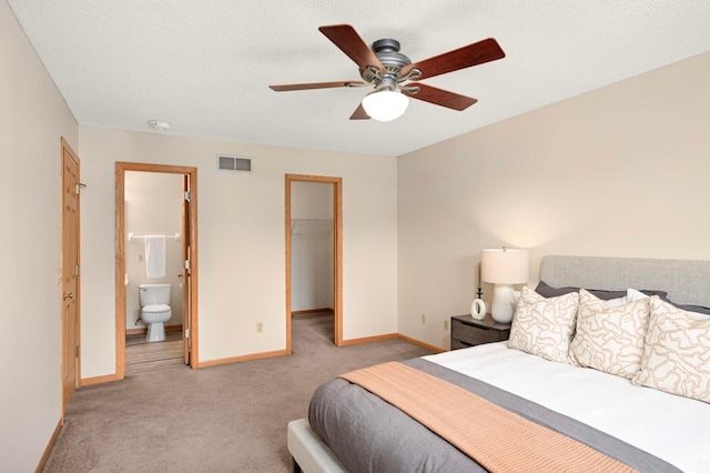 547 Woodduck Dr Unit G, Woodbury, MN 55125 - carpeted bedroom featuring baseboards, a spacious closet, a ceiling fan, connected bathroom, and a closet