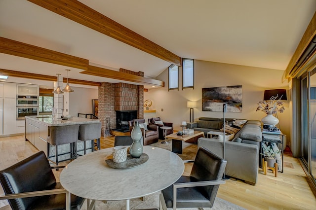 120 Eastbank Ct N, North Hudson, WI 54016 - dining area featuring light wood-type flooring, a fireplace, and healthy amount of natural light