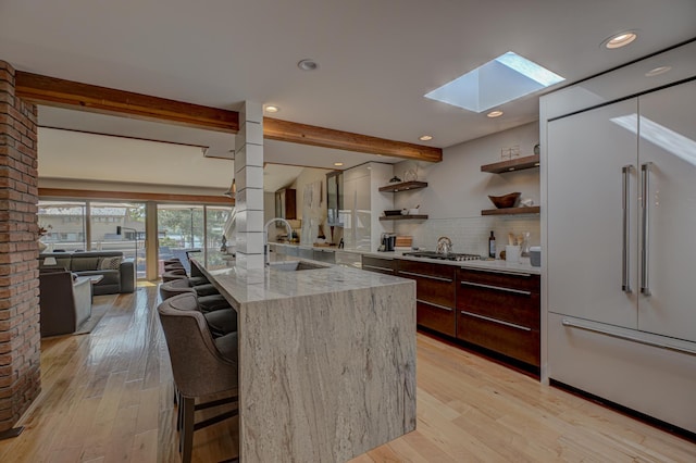 120 Eastbank Ct N, North Hudson, WI 54016 - kitchen with built in refrigerator, modern cabinets, a skylight, beamed ceiling, and tasteful backsplash